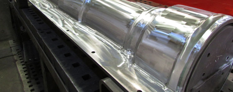 A silver custom metal stove pipe on a piece of equipment we use for our large custom metal fabrication services.